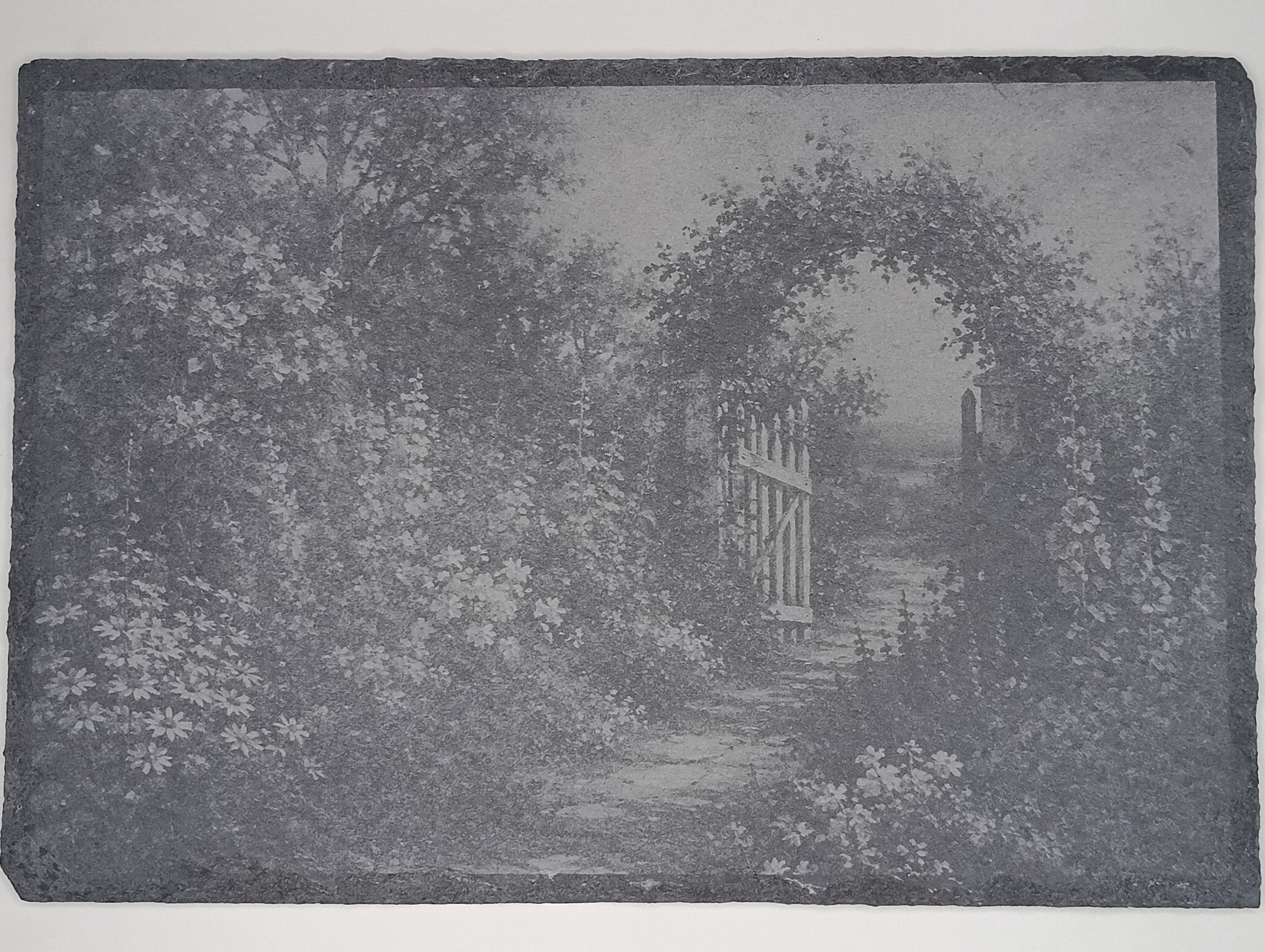 Decorative stone with a garden scene featuring a gate and archway.