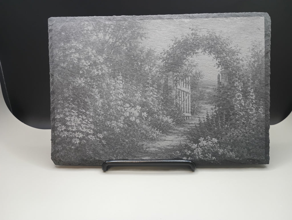 Decorative stone with a garden scene featuring a gate and archway.