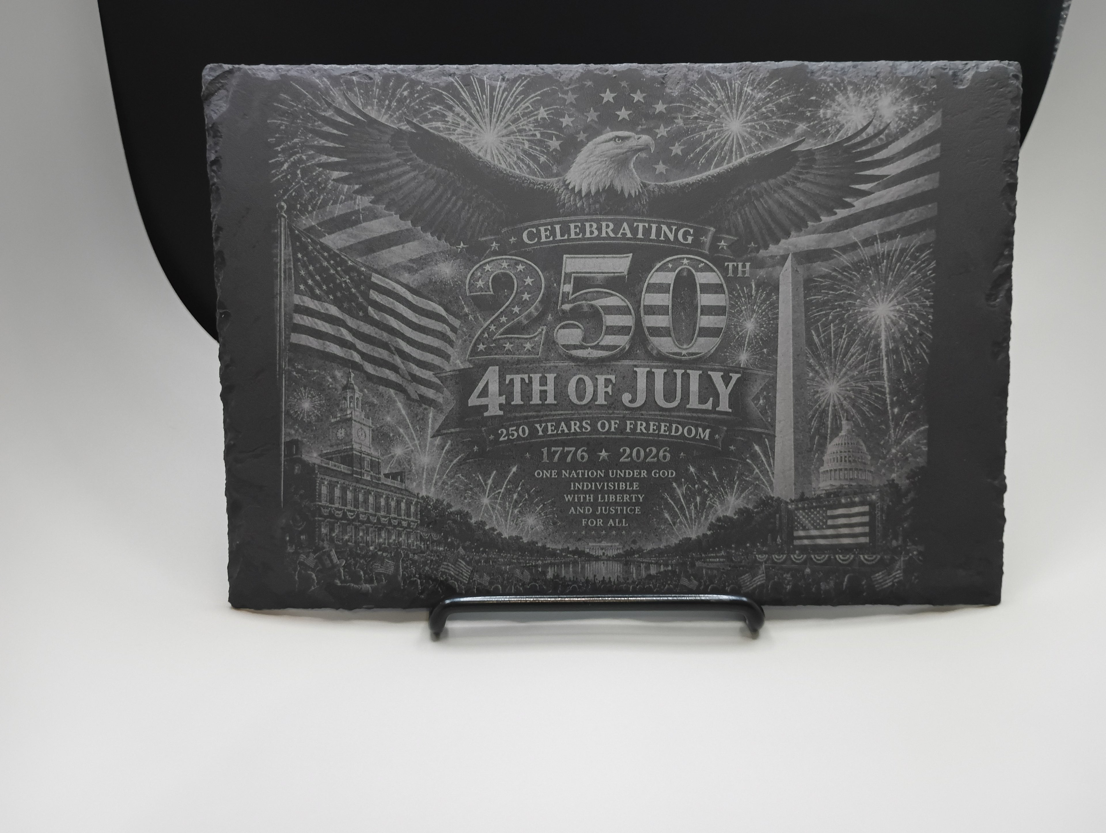 Decorative plaque celebrating the 250th anniversary of the 4th of July on a stand.