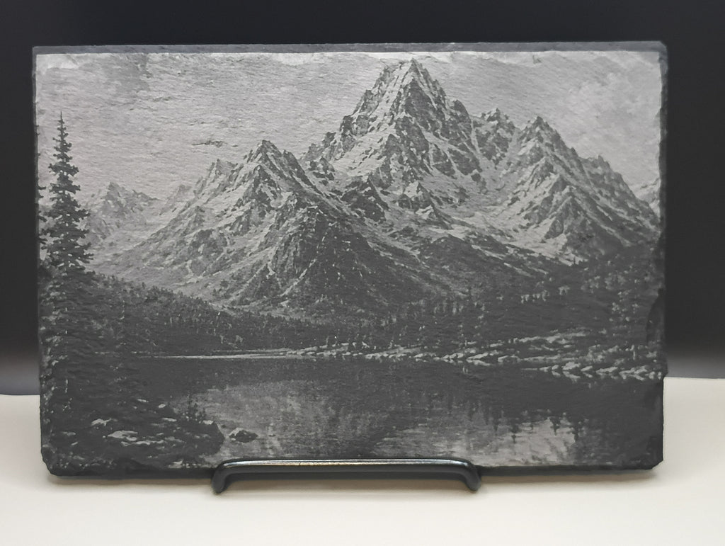 Slate with engraved mountain landscape on a white background