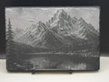 Slate with engraved mountain landscape on a white background